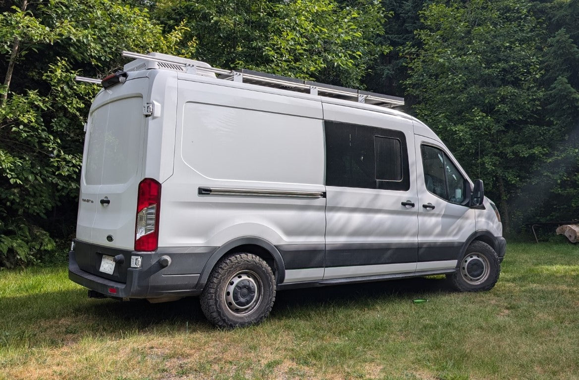 Custom campervan conversion parked in nature, showing an off-grid setup supported by the House2Start battery charger.